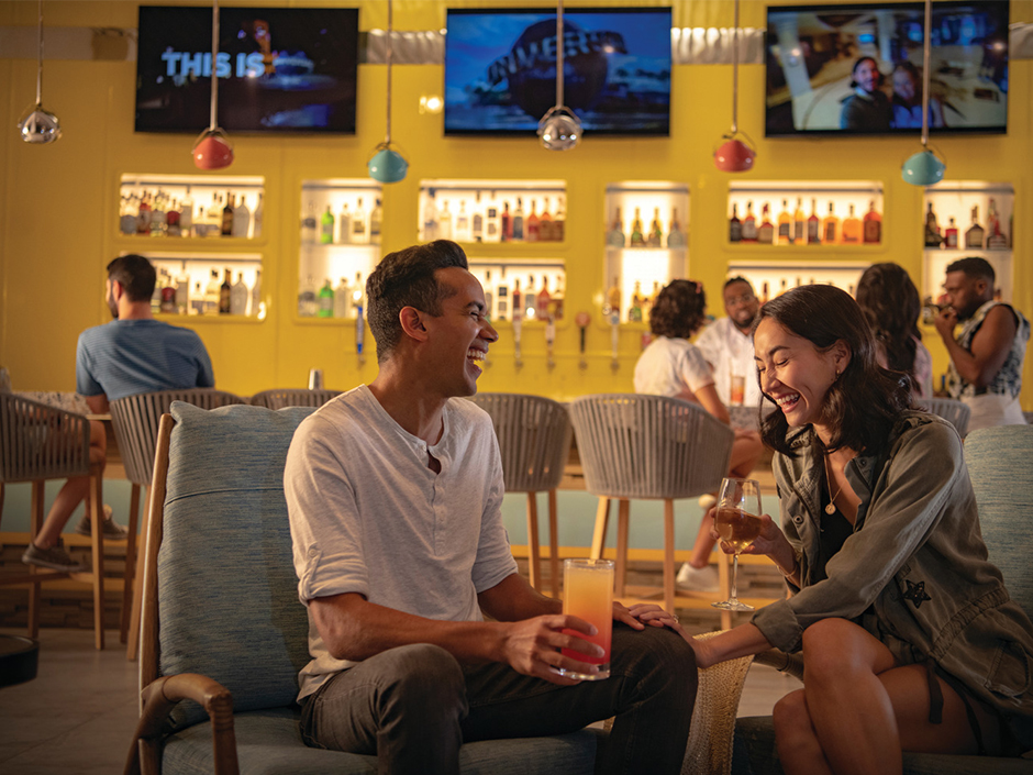 A man and a woman having a laugh at a bar in Dockside Hotel