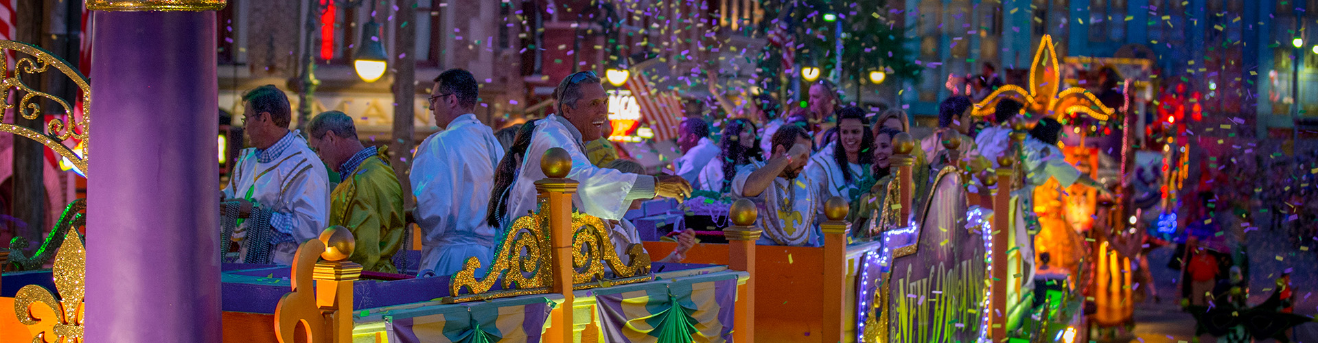 Guests on a Universal Mardi Gras float throw beads at the crowd