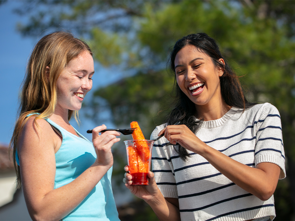 Two guests split Chamoy pineapple spears at Universal Studios Hollywood.