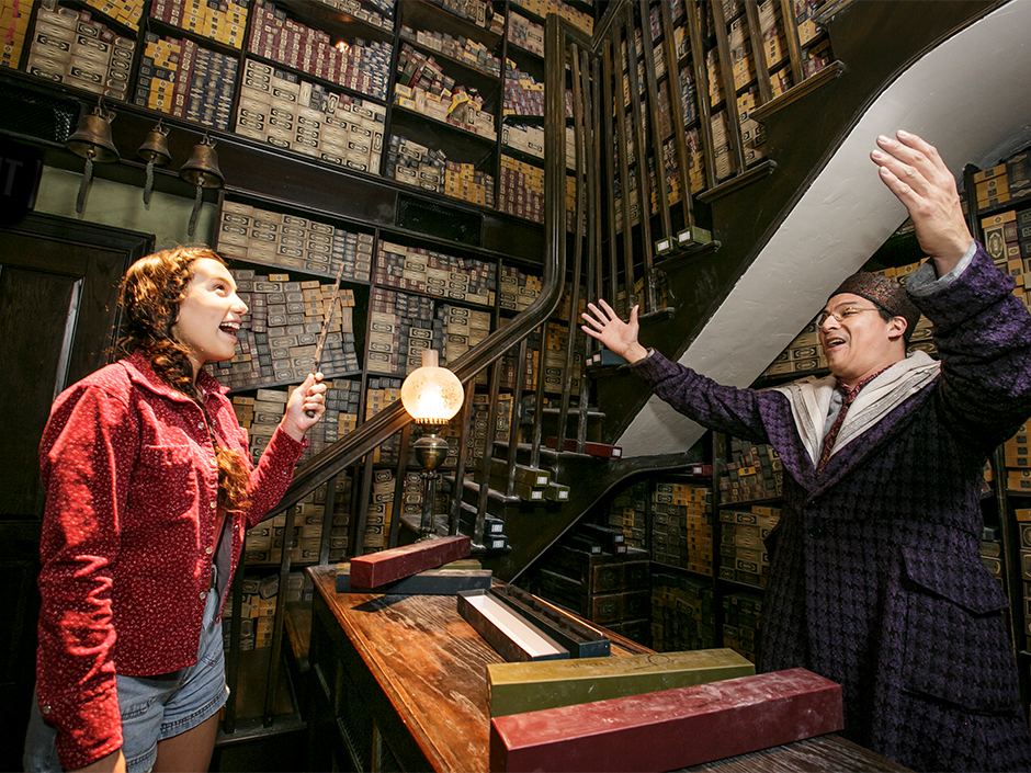 A guest is matched with a wand at Olivanders in The Wizarding World of Harry Potter.