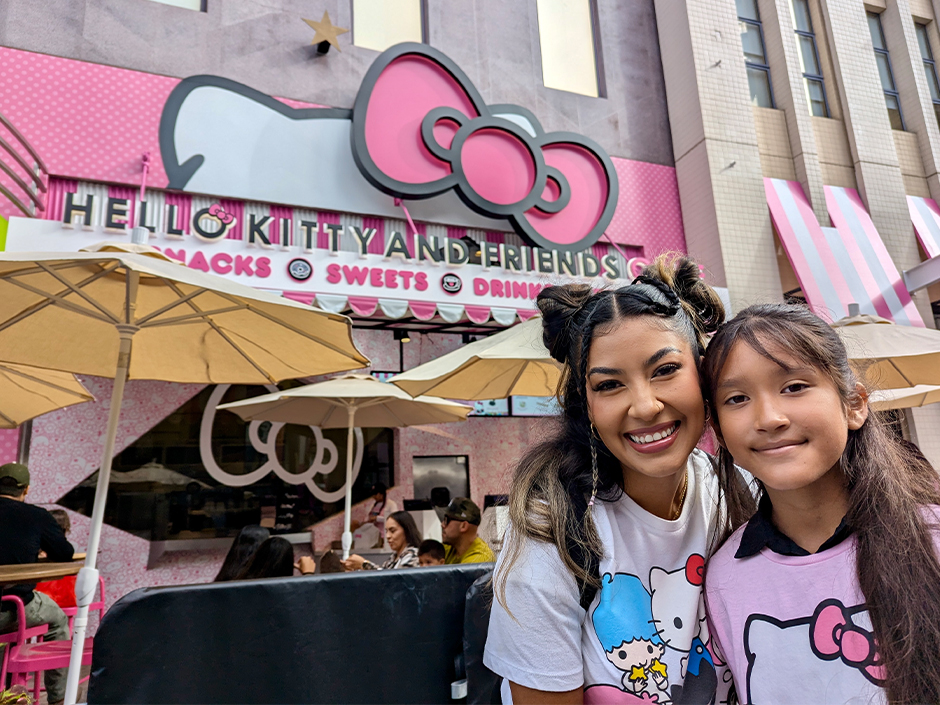 Two Hello Kitty fans posing in front of the Hello Kitty Cafe on Universal CityWalk Hollywood.