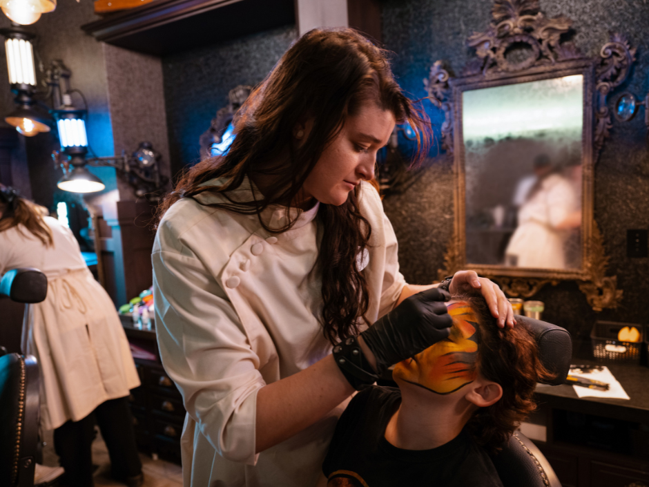 A makeup artist works on a guest in Darkmoor Monster Makeup Experience