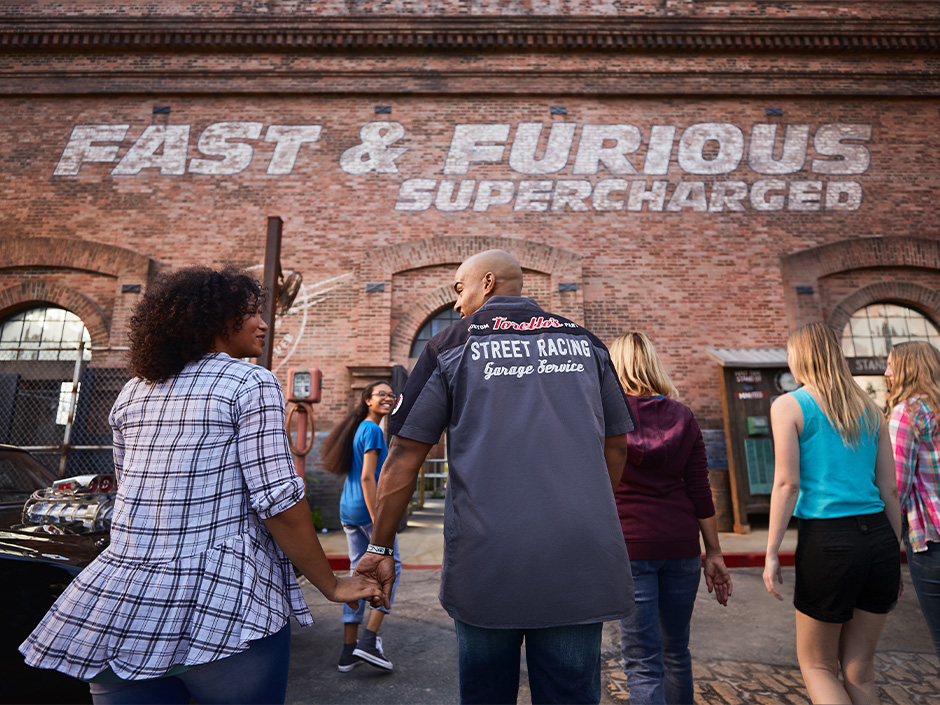A family laughs as they walk into Fast & Furious: Supercharged together