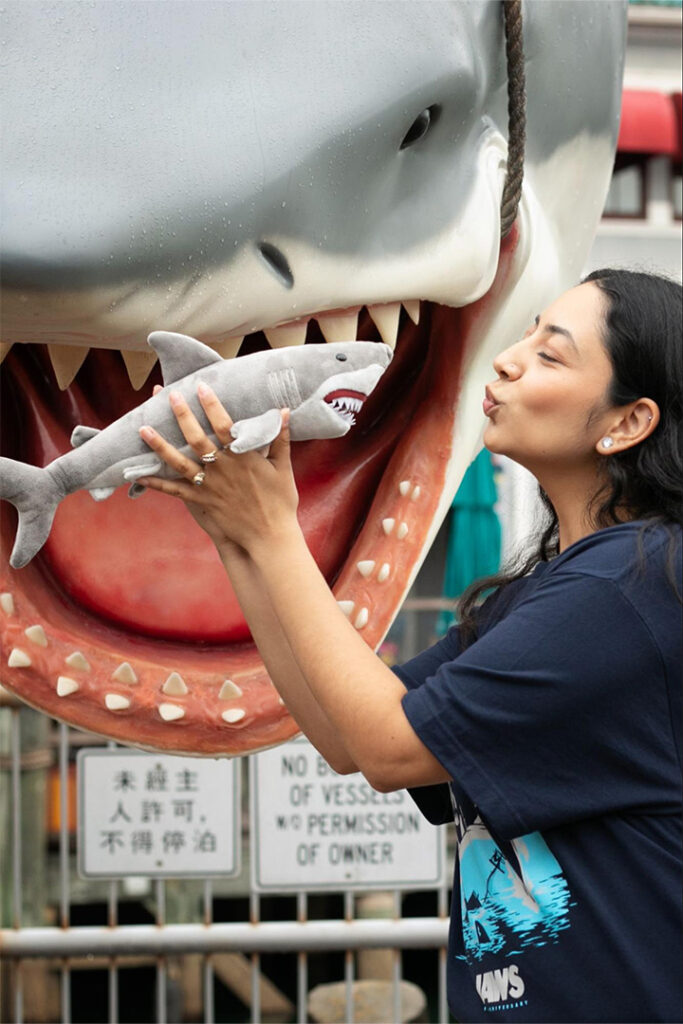 Uma garota posa com um boneco de pelúcia do Tubarão em frente à sessão de fotos no Universal Studios Florida