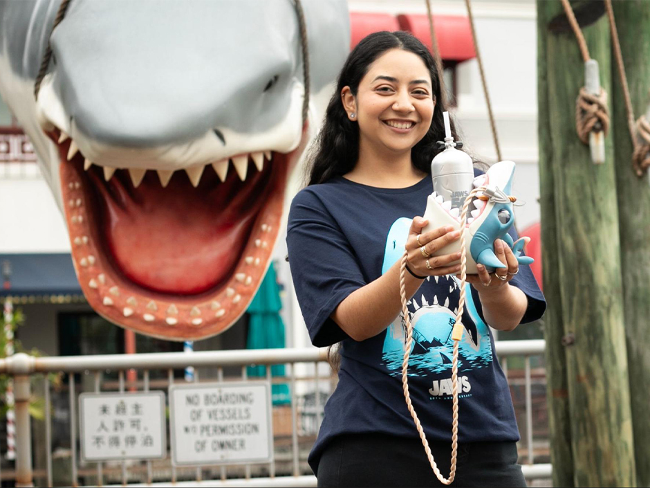 Uma garota sorrindo e segurando uma caneca de aniversário de Jaws