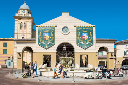 People walking outside of entrance of Portofino Bay Hotel