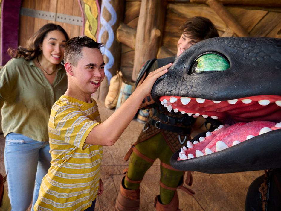 A young guest pets Toothless on the nose at Universal Epic Universe in the Isle of Berk