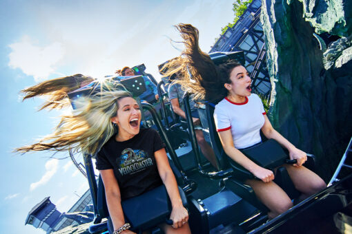 Two girls smile and scream as they ride Velocicoaster in Islands of Adventure