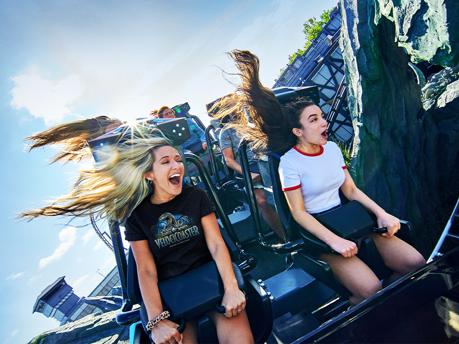 Two girls smile and scream as they ride Velocicoaster in Islands of Adventure
