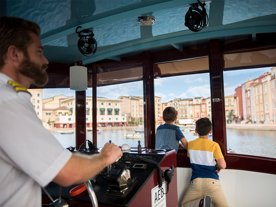 Two kids looking out of the water taxi as it approaches Portofino Bay