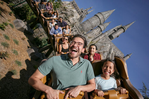 Guests on Flight of the Hippogriff, with Hogwarts Castle in the background.