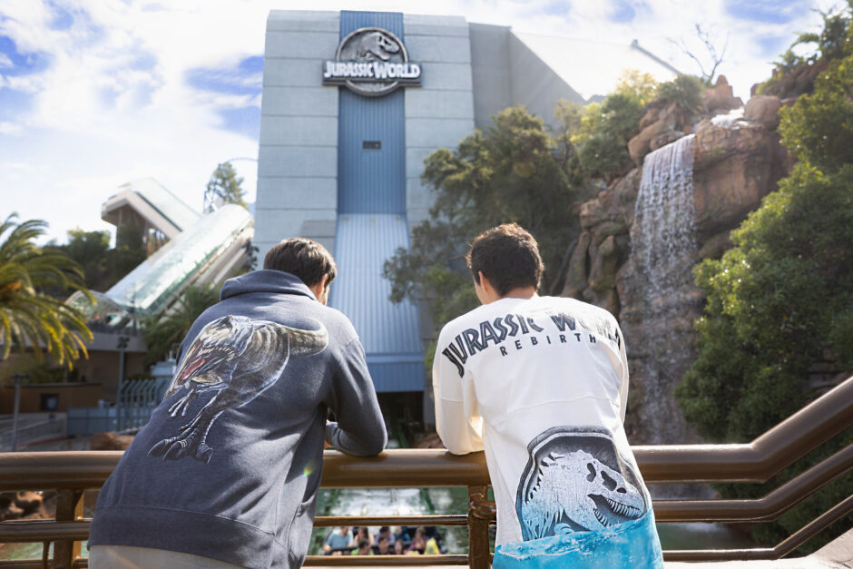 Guests sporting new Jurassic World Rebirth merchandise in front of Jurassic World - The Ride at Universal Studios Hollywood