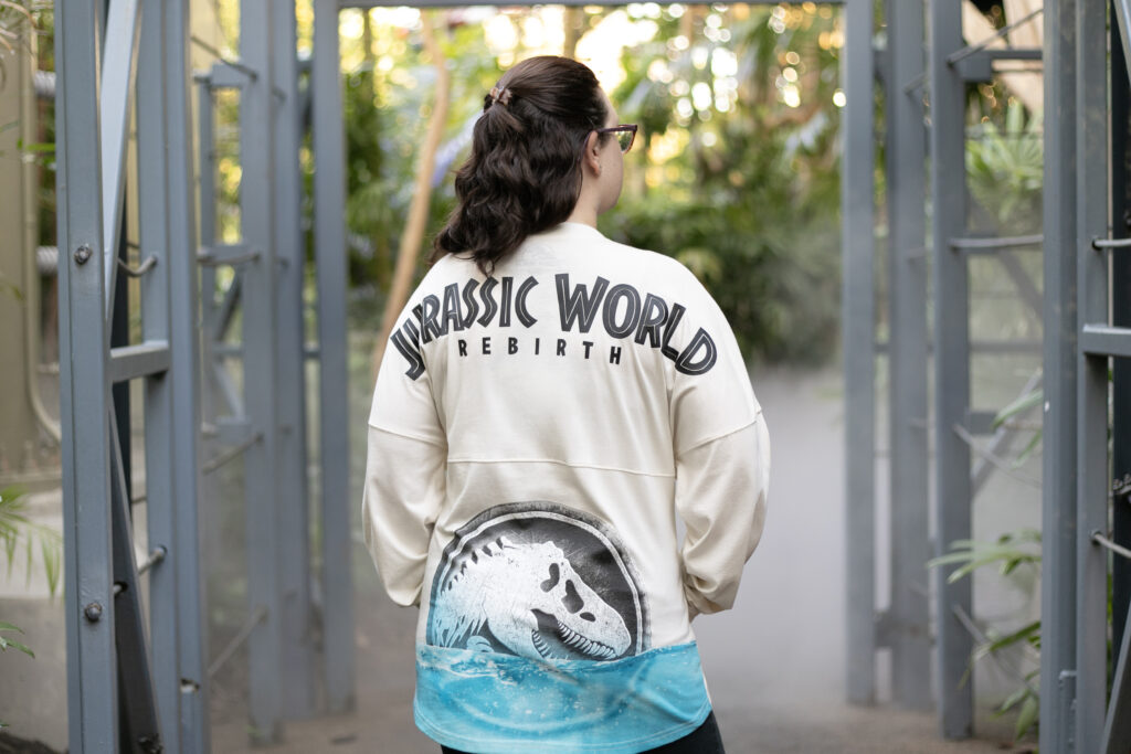 Woman wearing new Jurassic World Rebirth merchandise in Jurassic Park at Universal Orlando Resort