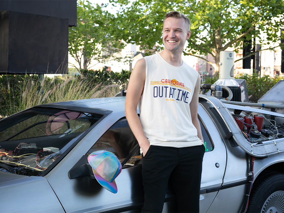 A guest poses in a Back to the Future tank near a time machine