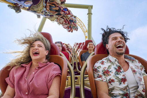 Guests smile as they ride Stardust Racers in Celestial Park