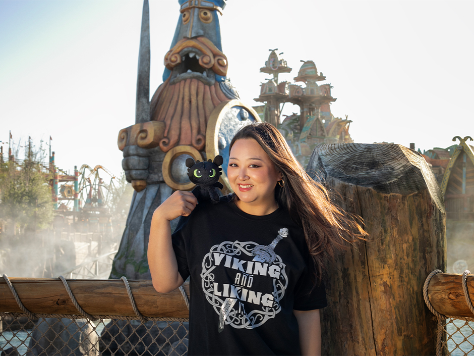 A guest poses with the Toothless Shoulder Pal in Isle of Berk at Epic Universe
