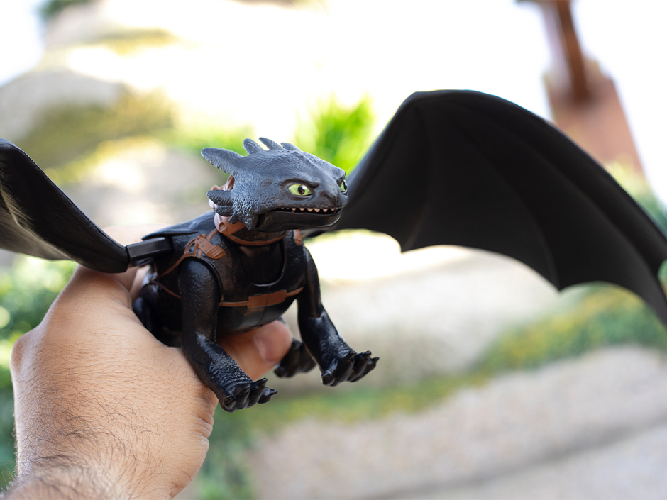 A guest holds an Ultimate Plasma Blast Toothless Toy