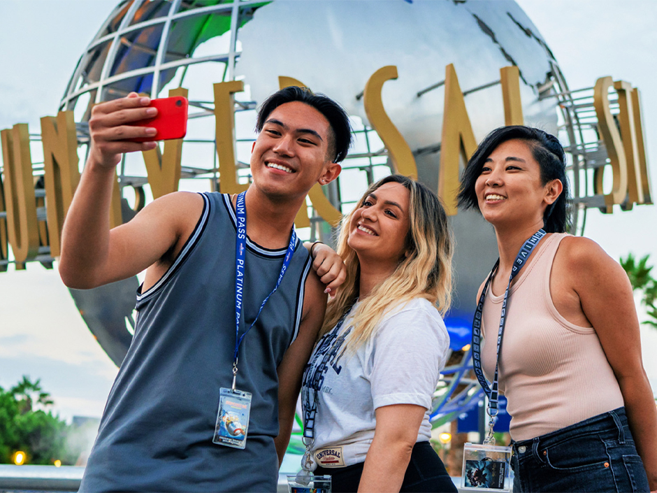 Three people posing for a picture in front of Universal Studios Hollywood globe