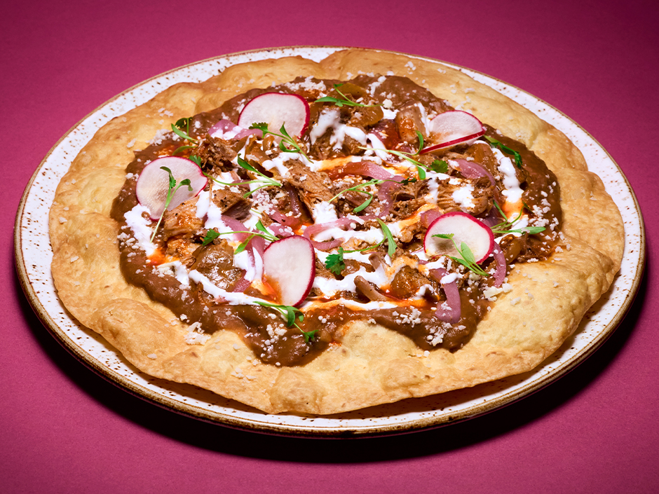 Plate of Tlayuda at Atojitos Authentic Mexican Food in Universal CityWalk for Universal Orlando Passholders.