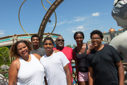 Maria Smith posing for a photo at Universal Epic Universe with her husband and children.