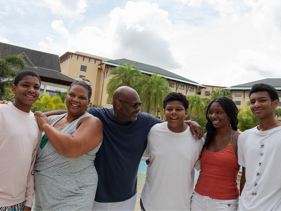 Maria Smith with her husband and children posing for a photo at Loews Royal Pacific Resort.