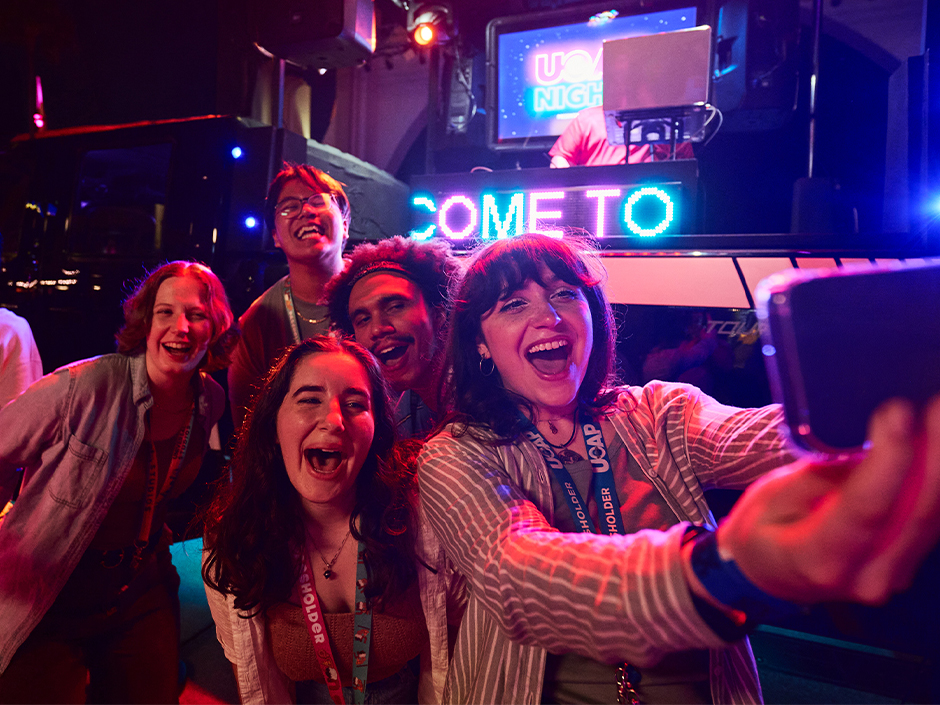 A group of Universal Passholders smile and pose for a selfie at Passholder Nights