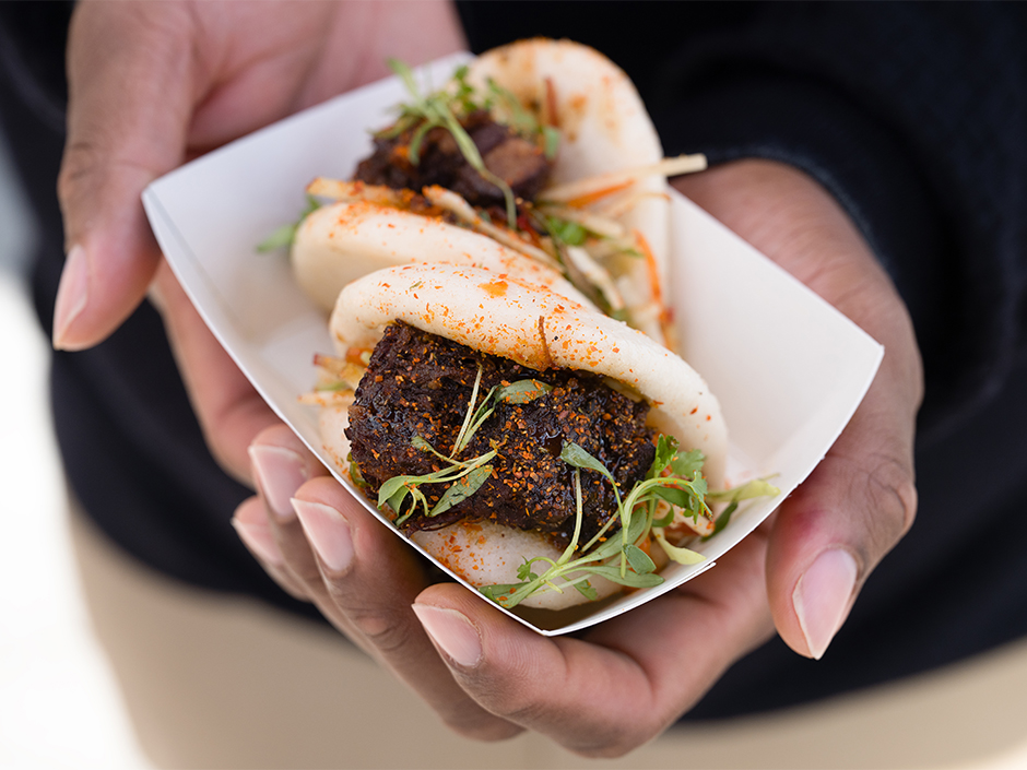 Hands holding the Seven Spice Beef Brisket Bao at Bend the Bao for Lunar New Year.