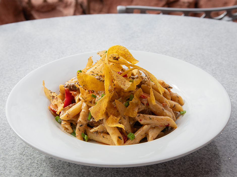 Plate of Braised Chicken Rasta Pasta at Mythos Restaurant for Women's Herstory Month.