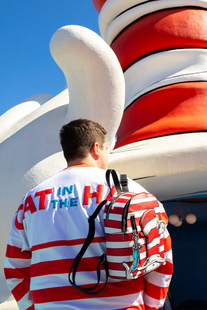 A guest poses in a Cat in the Hat spirit jersey with a Cat in the Hat backpack on his back