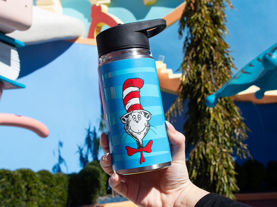 A guest holds up a blue striped water bottle with the Cat in the Hat on the front