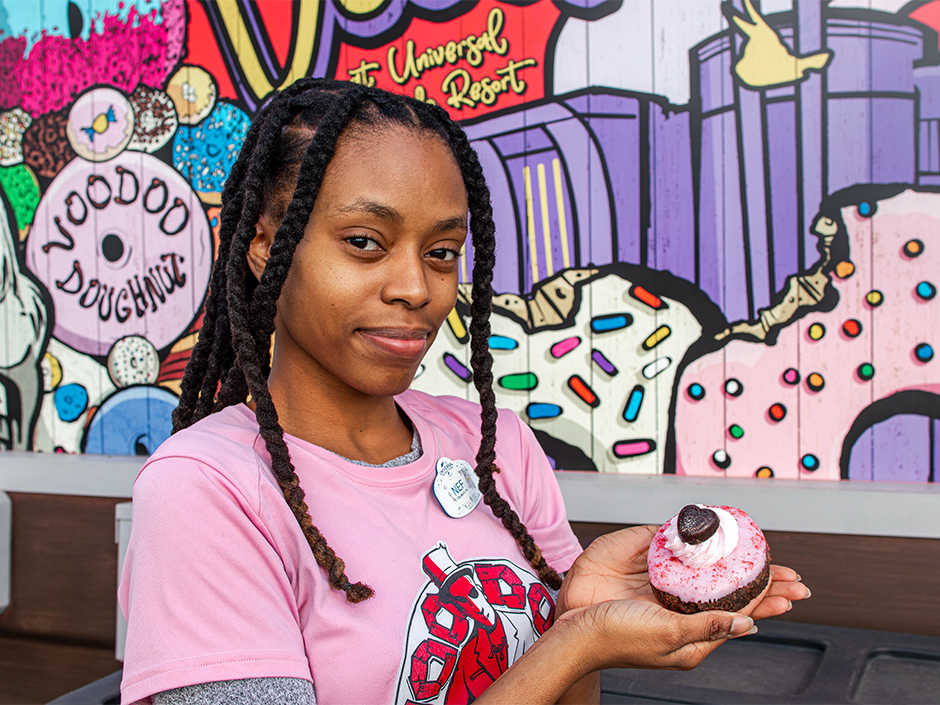 Voodoo Doughnut senior cook Briana Paul holding the Love Twist Valentine's Day doughnut she made.