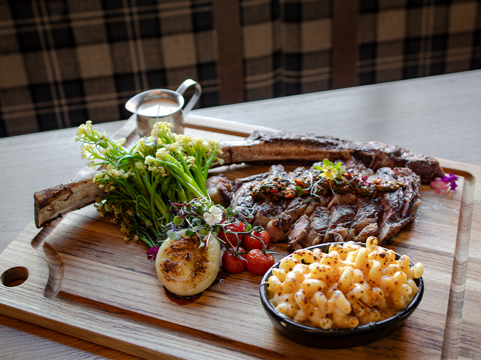 Sliced Rib Eye Tomahawk with a side of broiled caulilini and mac and cheese at Bigfire for Valentine's Day in Universal CityWalk.