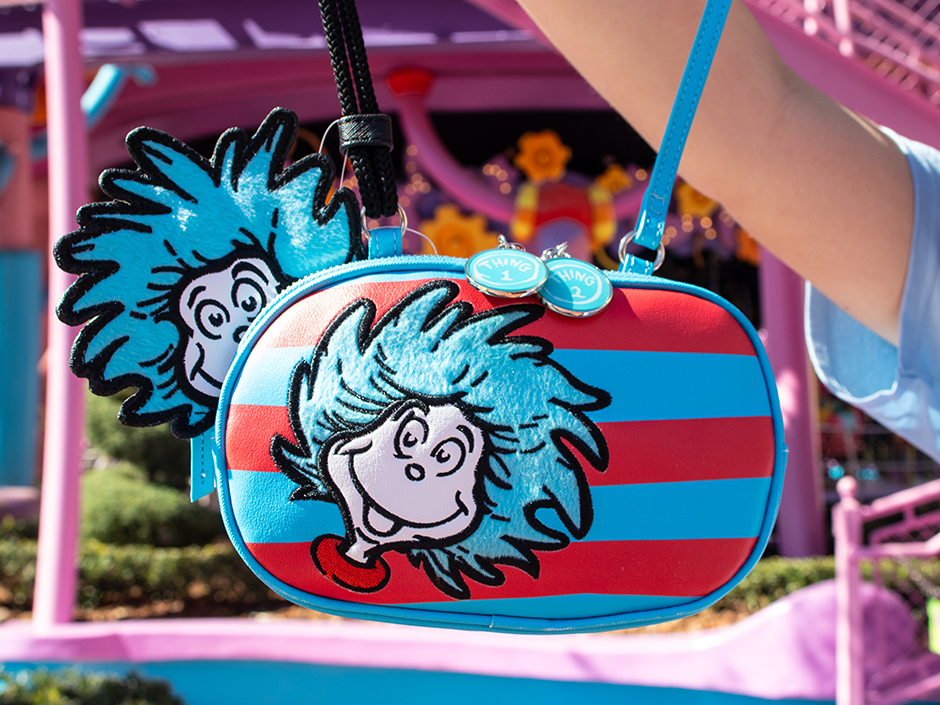 A guest holds up a crossbody purse featuring red and blue stripes and Thing 1 and Thing 2