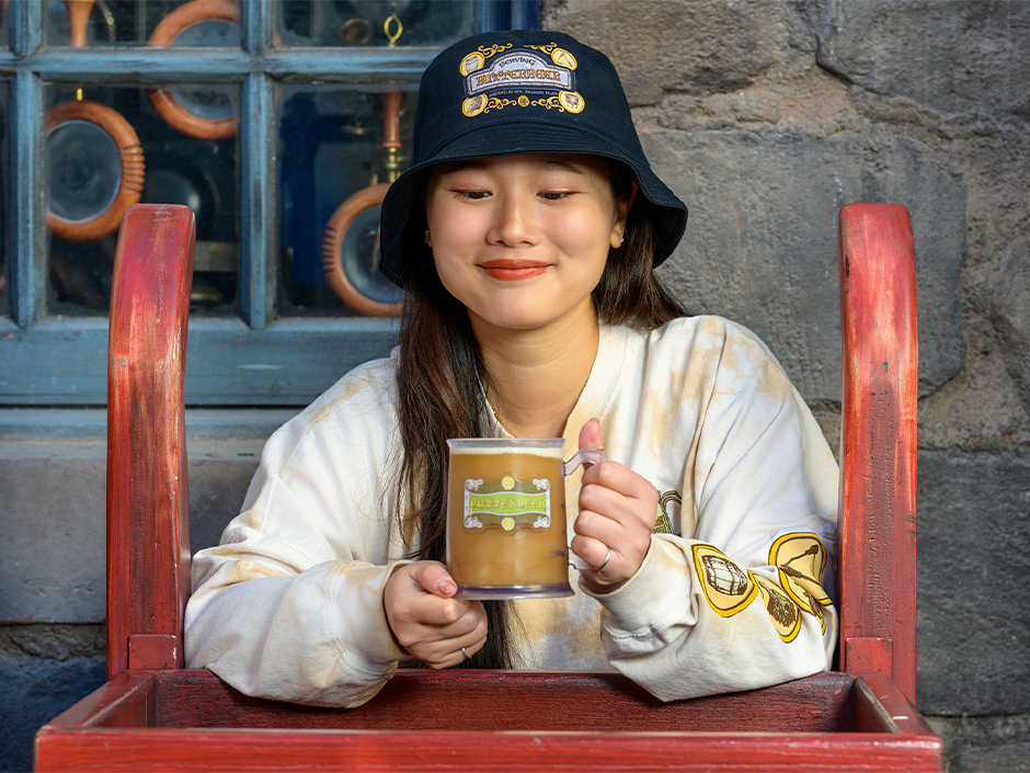 Guest wearing merchandise celebrating Butterbeer, available in The Wizarding World of Harry Potter.