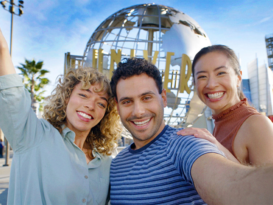 Three guests pose in front of the Universal globe for a selfie at USH.