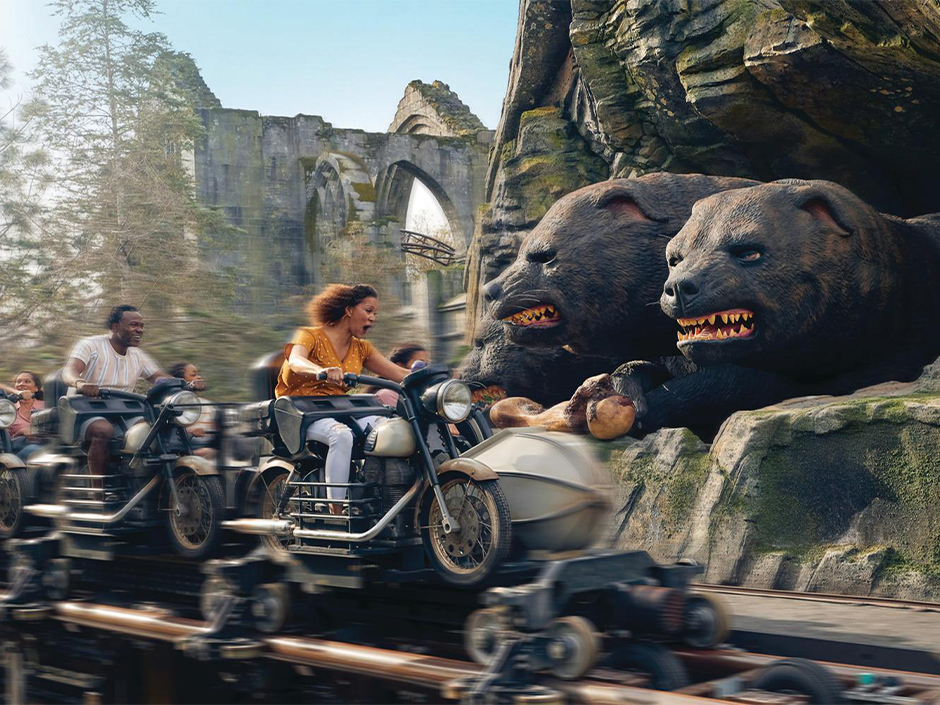Guests speed past Fluffy on Hagrid's Magical Creatures Motorbike Adventure at Islands of Adventure