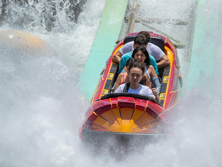 People riding Dudley Do-Right’s RipSaw Falls. 
