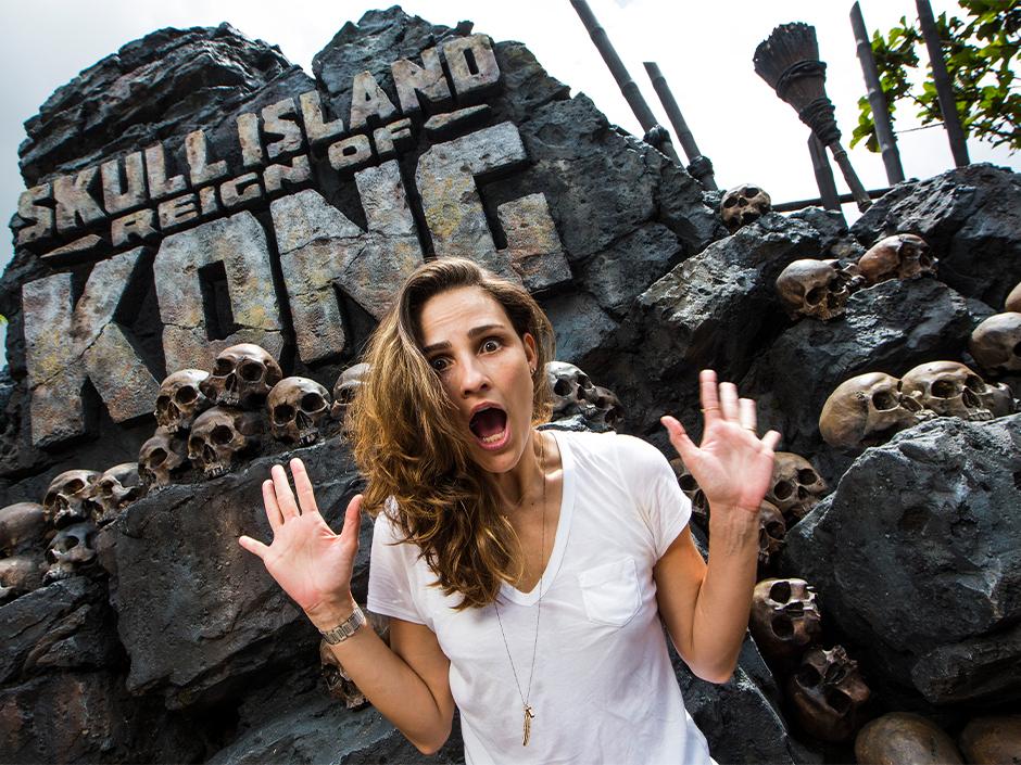 Woman posing with a frightened expression in front of Skull Island Reign of Kong.