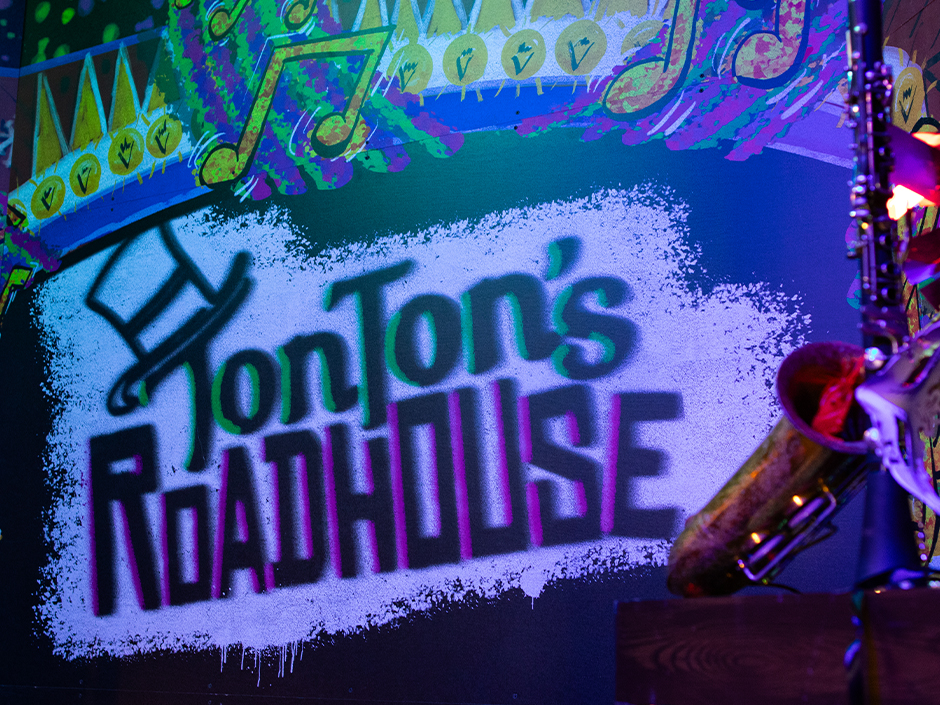 A projection of the TonTon's Roadhouse logo on the wall in the Universal Mardi Gras Tribute Store