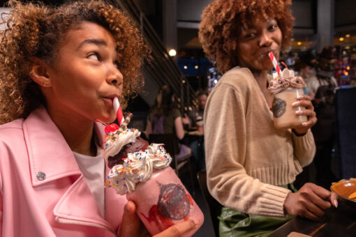 A mother and daughter enjoying milkshakes at Toothsome Chocolate Emporium and Savory Feast Kitchen.