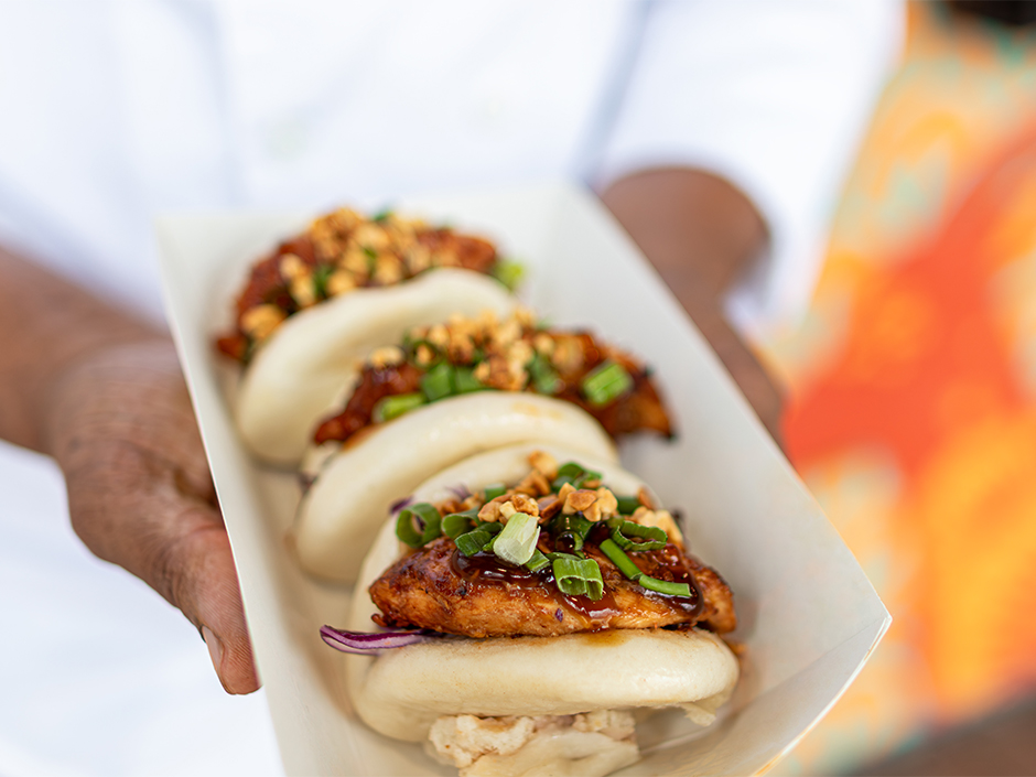 Hands holding Huli Bao Buns at Bend the Bao for AANHPI Heritage Month at Universal Orlando Resort.