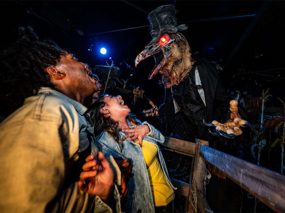 Guests get scared by a terrifying creature at Halloween Horror Nights.