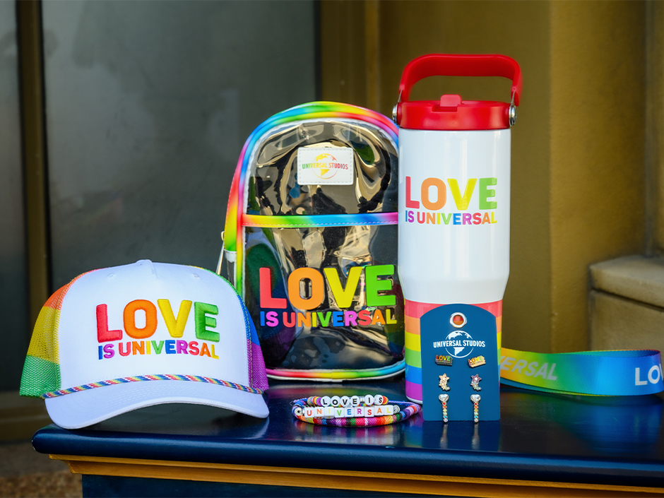 Love is Universal merchandise, including a baseball hat, a backpack, and a tumbler