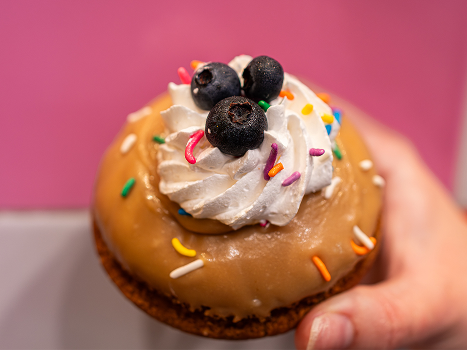 Hand holding the Breakfast for Dad doughnut at Voodoo Doughnut for Father's Day.