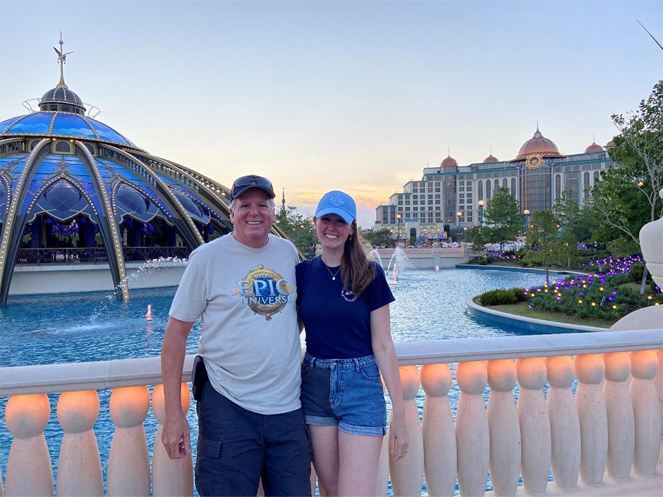 Kaitlyn and her father pose side-by-side in front of Constellation Carousel