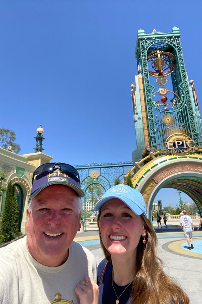 Kaitlyn and her father smile in a selfie near the Chronos portal at Epic Universe