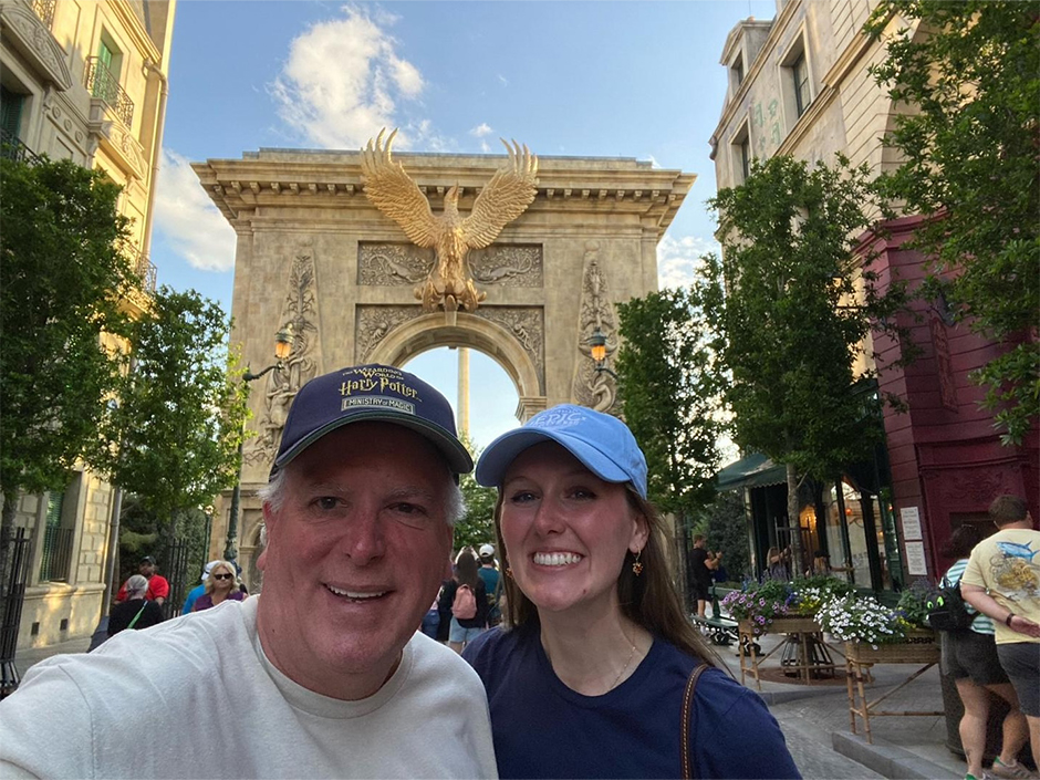 Kaitlyn and her dad smile for a photo in Ministry of Magic at Epic Universe