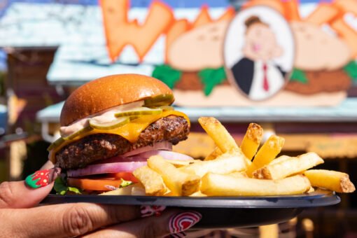 A burger is held up outside of Wimpy's