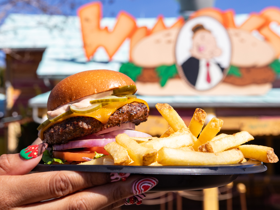 A burger is held up outside of Wimpy's