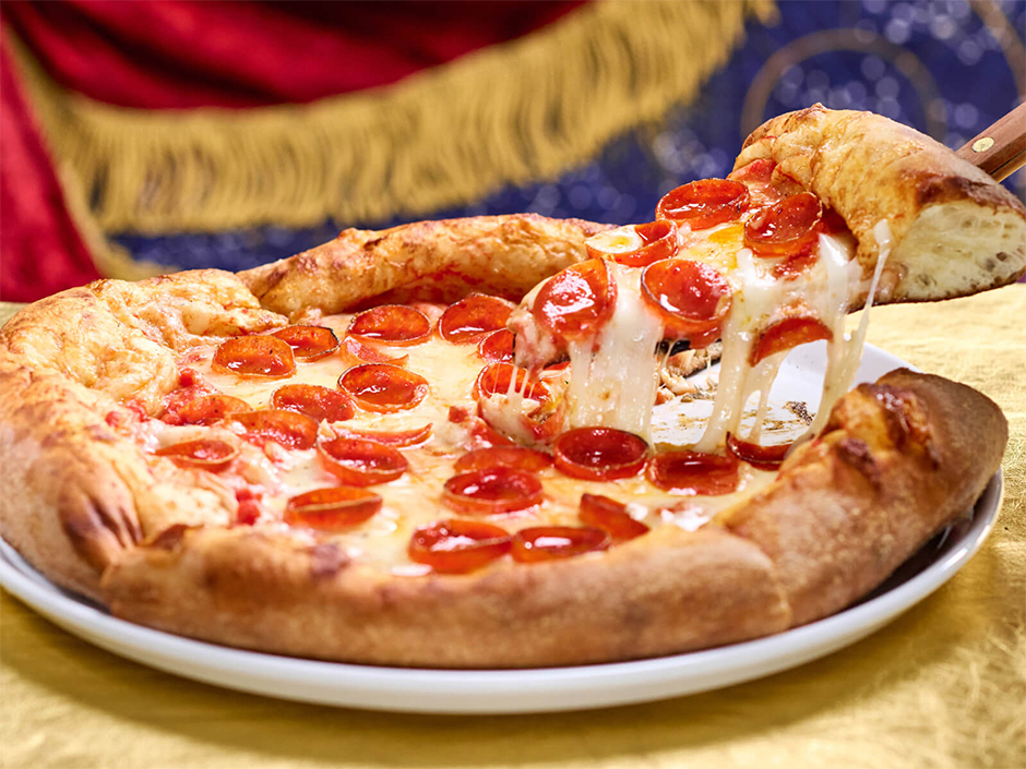 A pizza moon pepperoni pizze, a slice with a cheese pull is held up